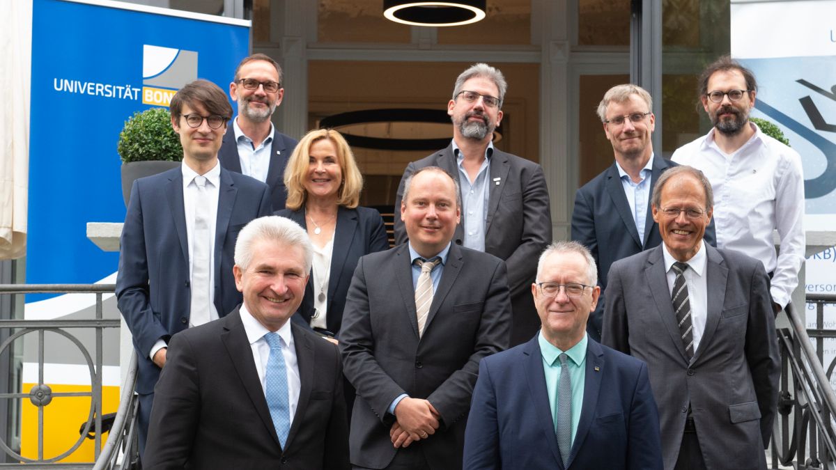 Gruppenbild mit Minister: Nach der Übergabe des Förderbescheids stellten sich die Teilnehmenden vor dem Rektoratsgebäude für ein Gruppenfoto auf. Gruppenbild
