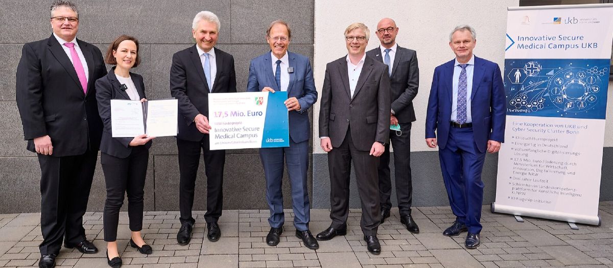 (v.l.) Dirk Backofen, Deutsche Telekom/T-Systems, Prof. Ulrike Attenberger, Direktorin Klinik für Radiologie des UKB, Innovationsminister Prof. Andreas Pinkwart, Prof. Wolfgang Holzgreve, Ärztlicher Direktor und Vorstandsvorsitzender des UKB, Dr. Christian Temath, KI.NRW, Clemens Platzköster, Kaufmännischer Direktor des UKB und Stephan Wirtz, Cyber Security Cluster Bonn, bei der Übergabe des vorläufigen Zuwendungsbescheids